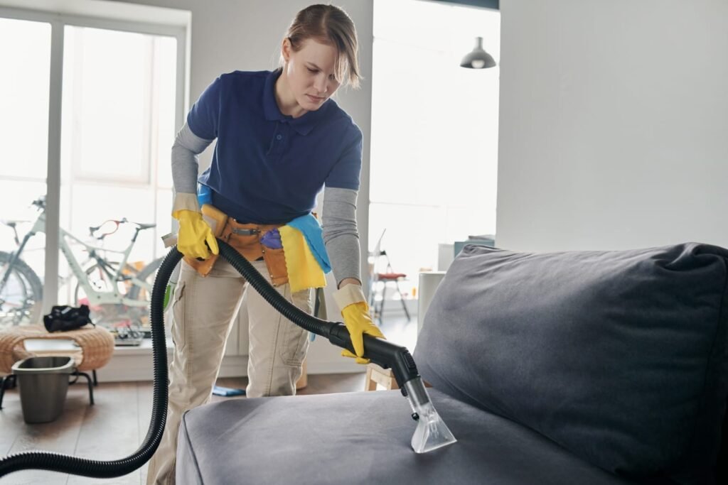 woman cleaning sofa set